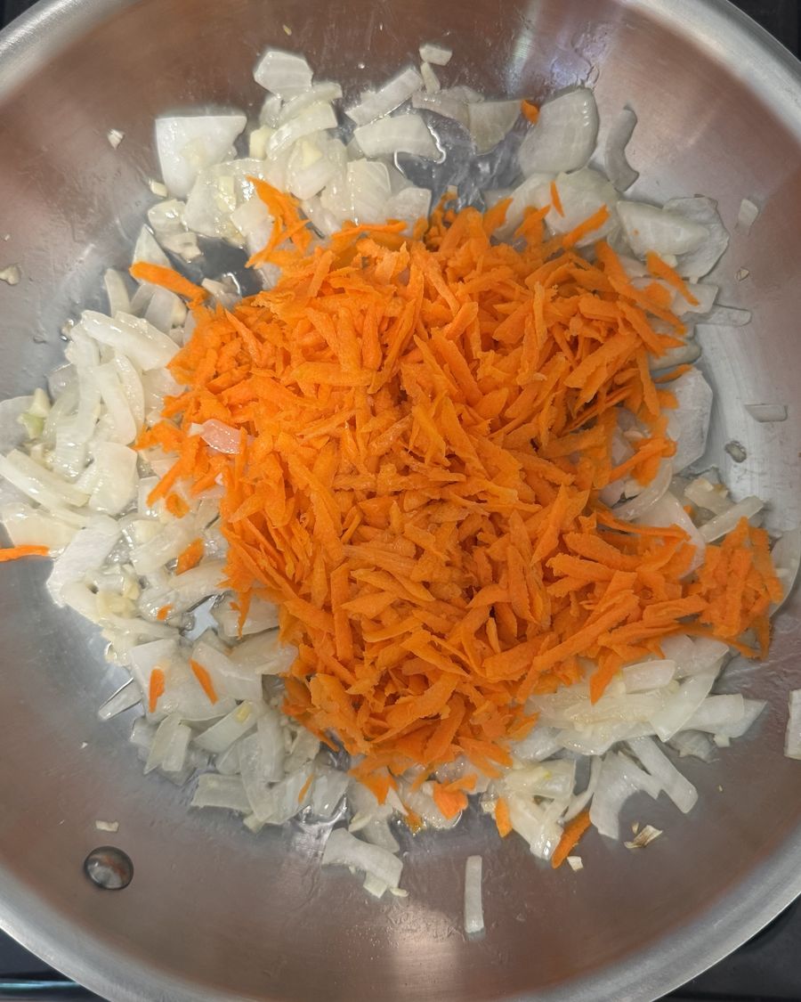 Grated carrot added to pan